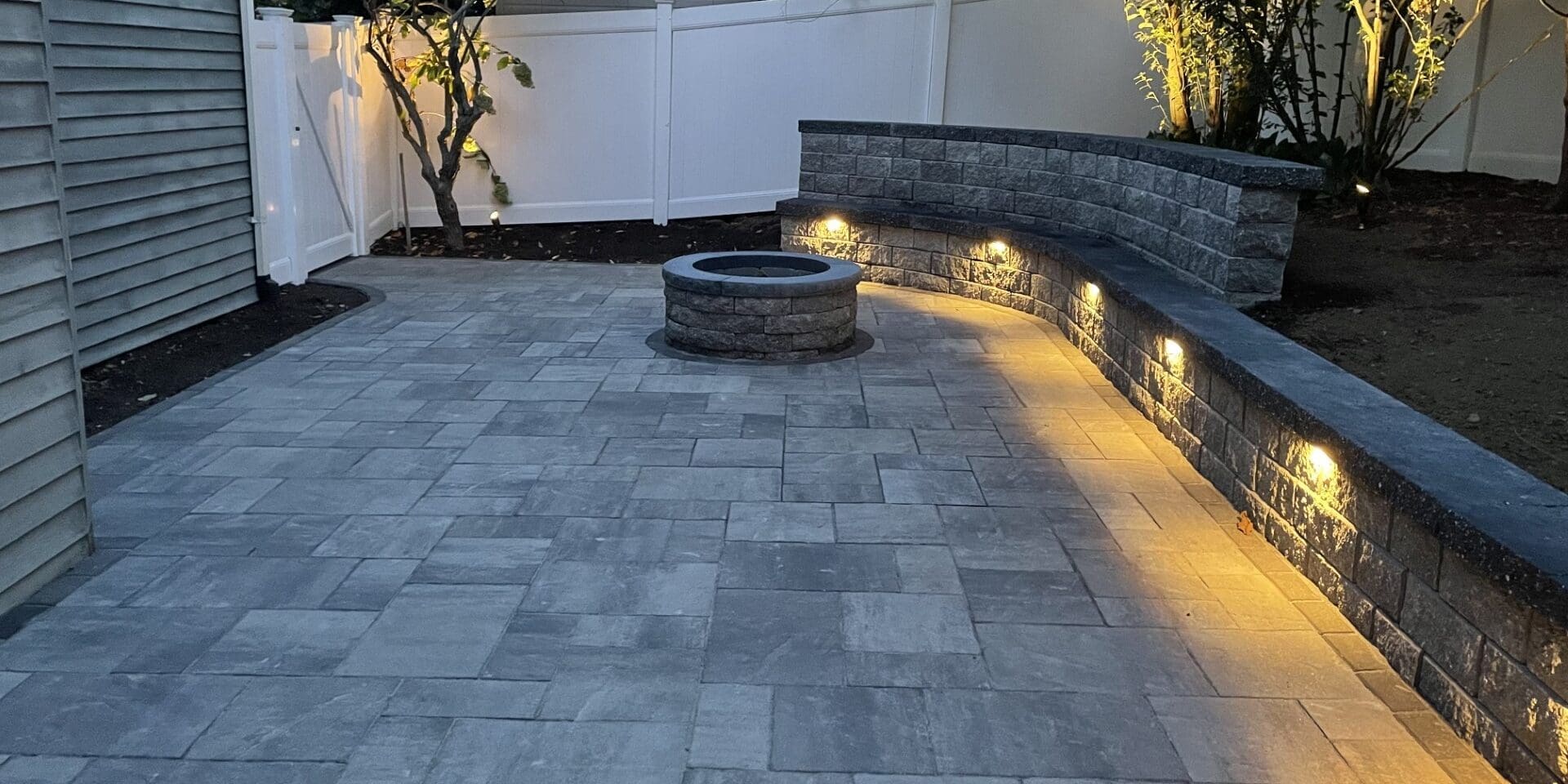 outdoor kitchen design with beautiful landscape lighting and stone paving.